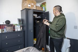 Damien putting clothes away in his wardrobe he received from Home Start Uk’s corporate partner HappyBeds on the 22nd of January 2022 in the Medway region of Kent. The family are currently living in temporary accommodation and have been receiving support from from HomeStart Medway. (photo by Andy Aitchison / HomeStart UK)